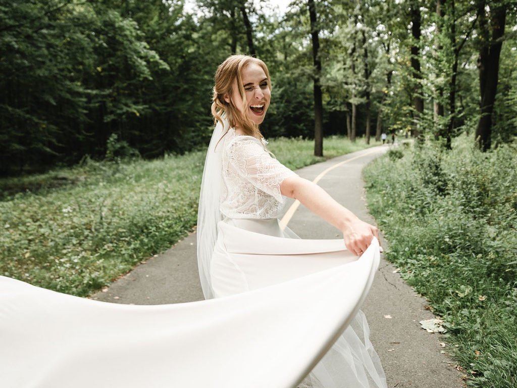 Bride twirls dress around against outdoor greenery